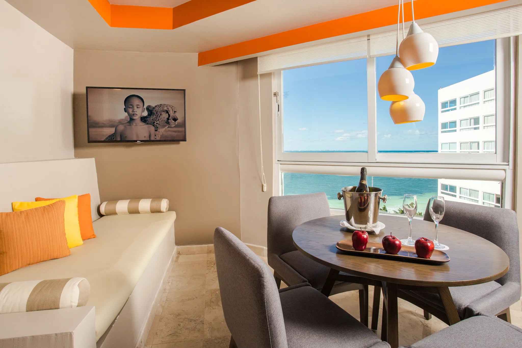 Deluxe Family living and dining area with ocean views at Dreams Sands Cancun Resort & Spa.