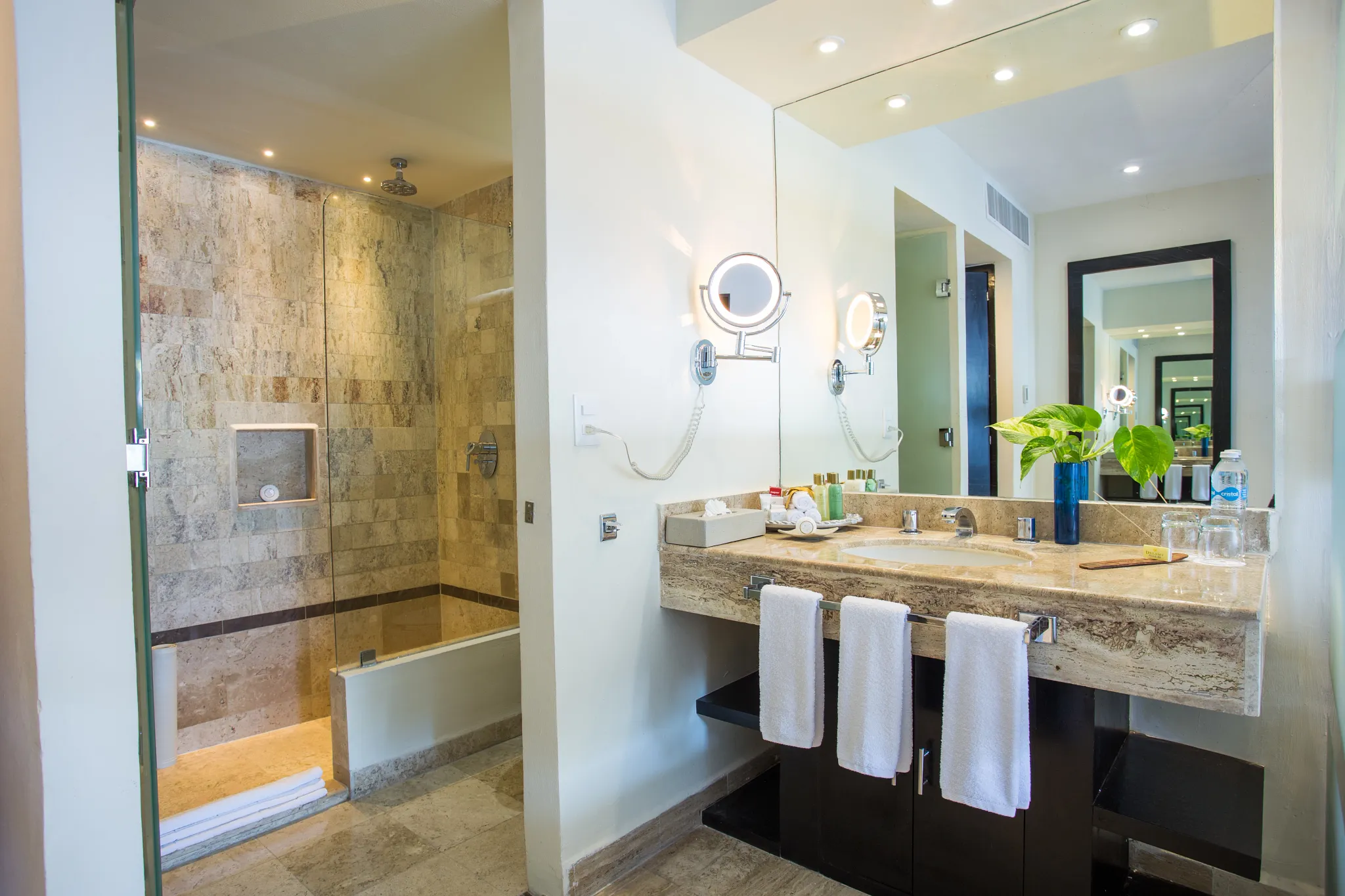 Deluxe Ocean Front bathroom with marble finishes and walk-in shower at Dreams Sands Cancun Resort & Spa.