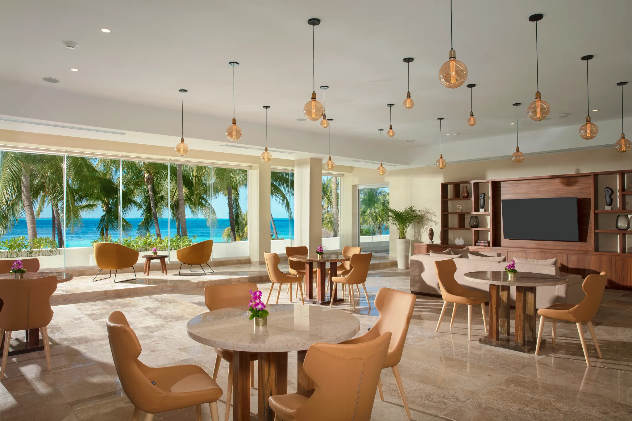 Elegant dining and lounge area with ocean views at Dreams Sands Cancun Resort & Spa.