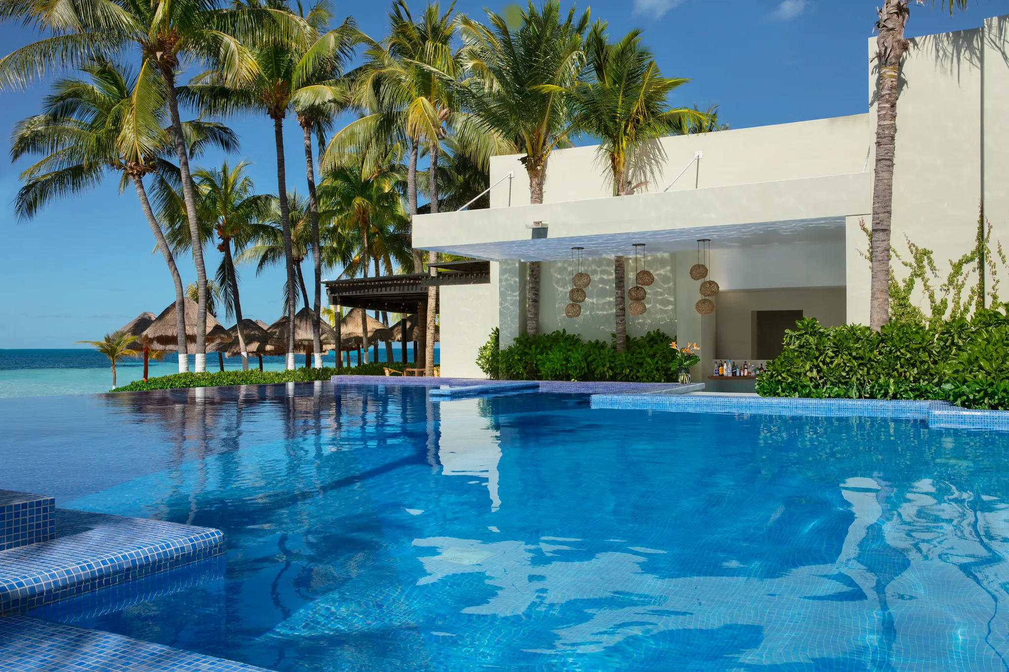 Manatees swim-up bar at Dreams Sands Cancun Resort & Spa featuring tropical cocktails, poolside seating, and relaxed beachfront ambiance.