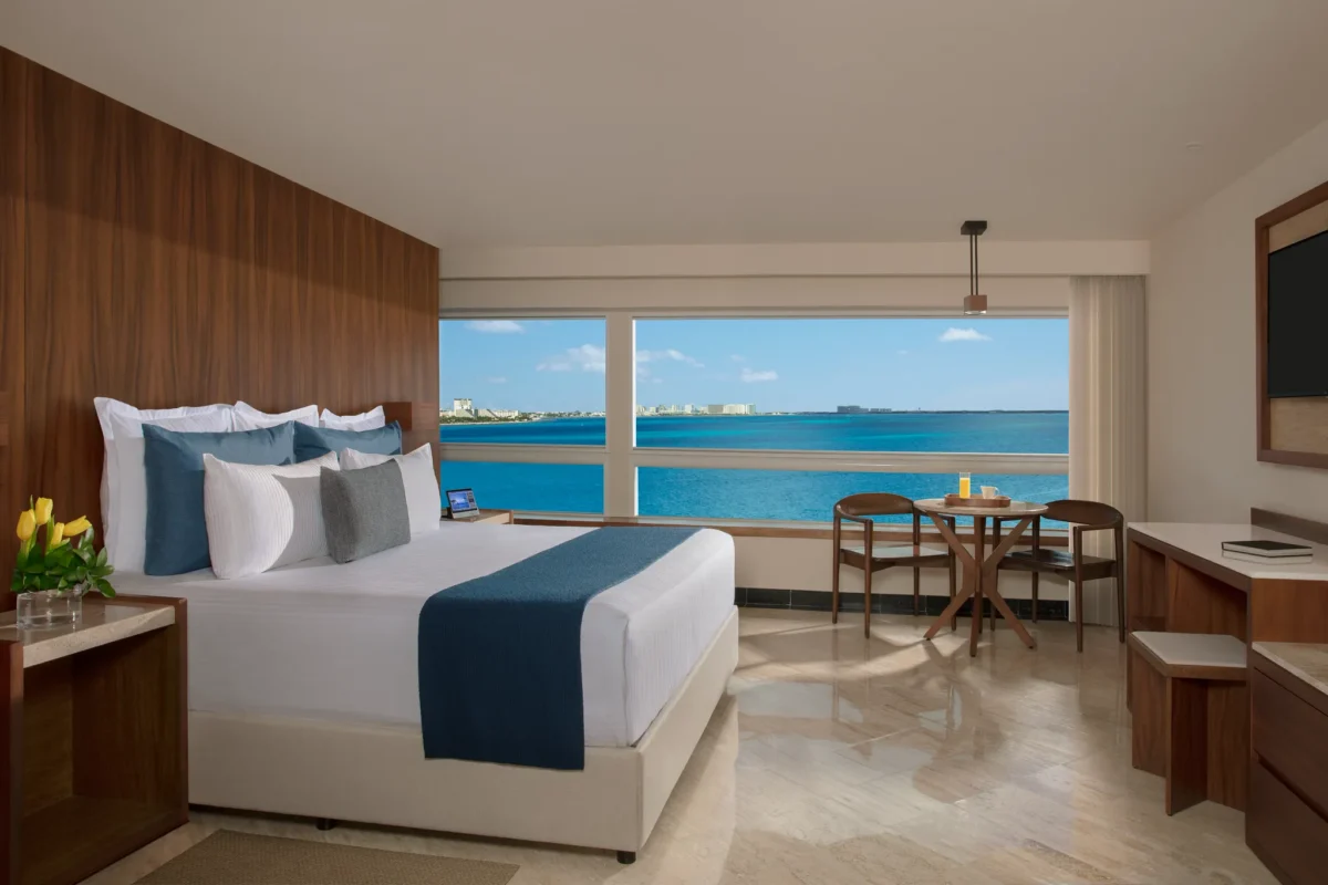 Preferred Club Junior Suite king bedroom with panoramic oceanfront views at Dreams Sands Cancun Resort & Spa.