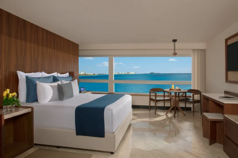 Preferred Club Junior Suite king bedroom with panoramic oceanfront views at Dreams Sands Cancun Resort & Spa.