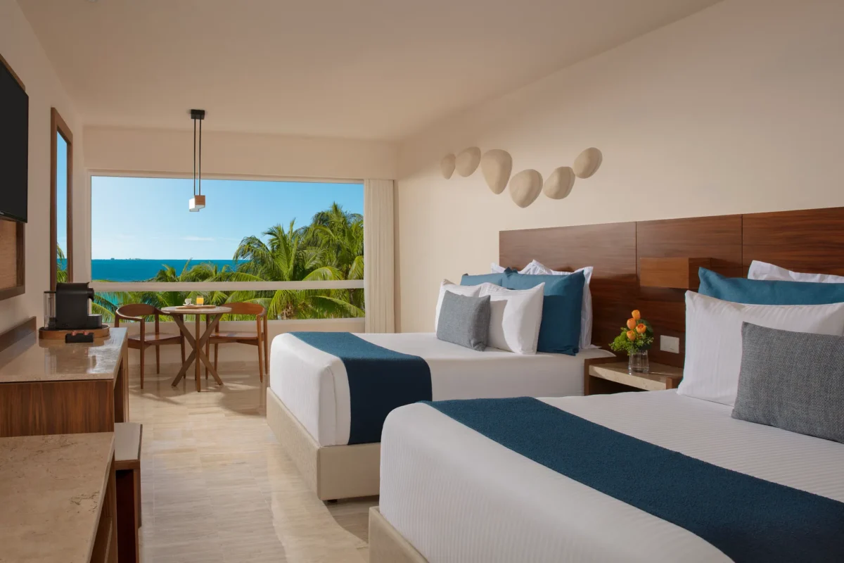 Premium Partial Ocean View room with two double beds and tropical ocean views at Dreams Sands Cancun Resort & Spa.