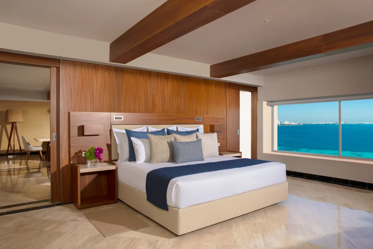 Presidential Suite bedroom with king bed and oceanfront views at Dreams Sands Cancun Resort & Spa.