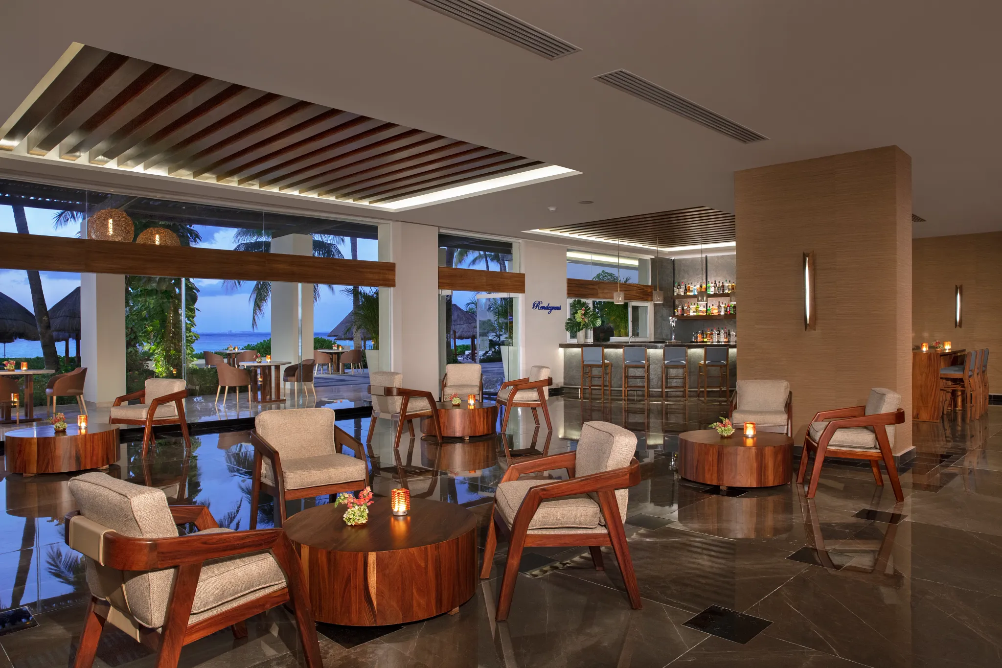 Rendezvous lobby bar at Dreams Sands Cancun Resort & Spa featuring stylish lounge seating, handcrafted cocktails, and elegant social atmosphere.