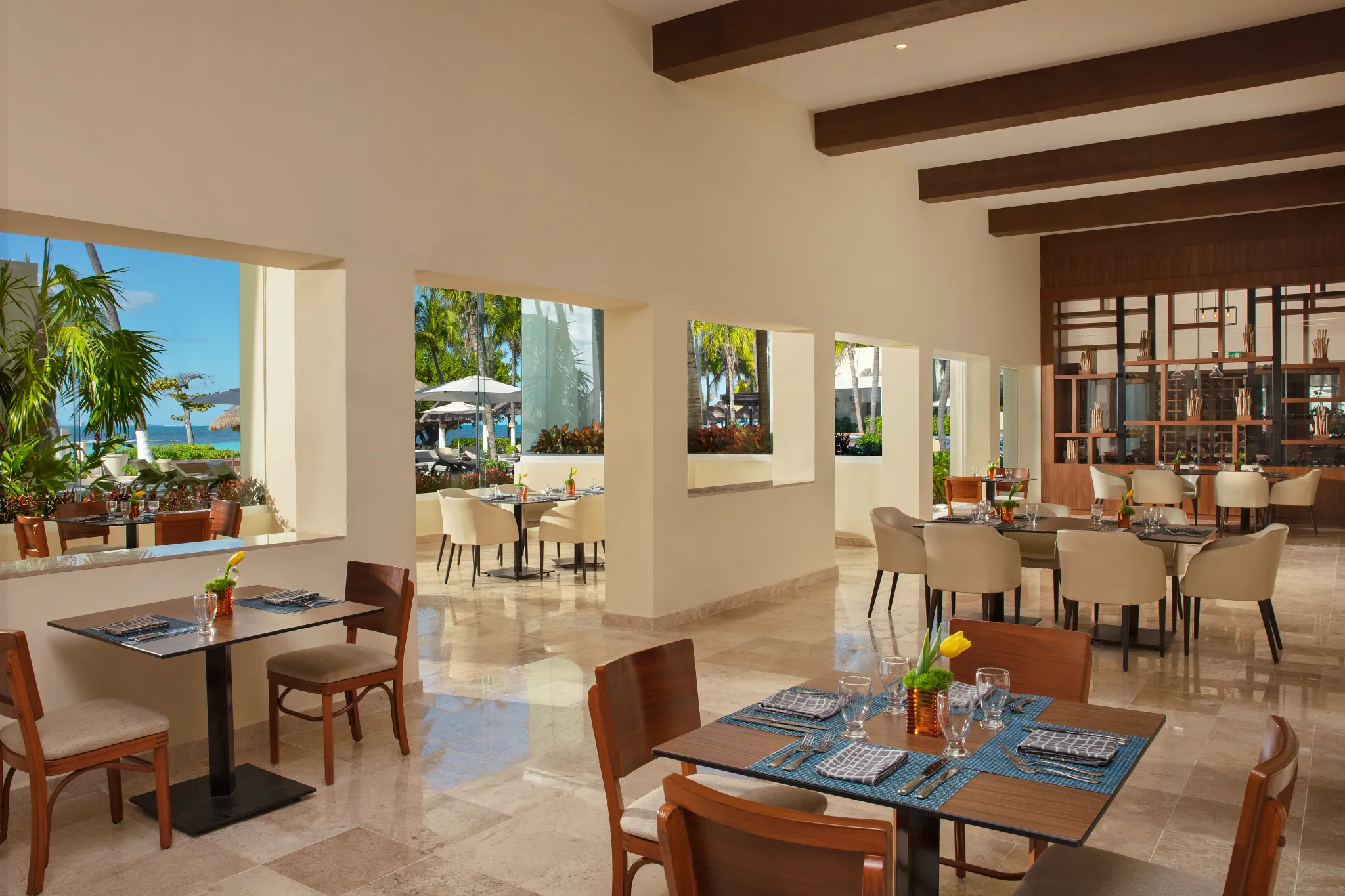 World Café buffet restaurant at Dreams Sands Cancun Resort & Spa featuring international cuisine stations, modern dining décor, and family-friendly atmosphere.